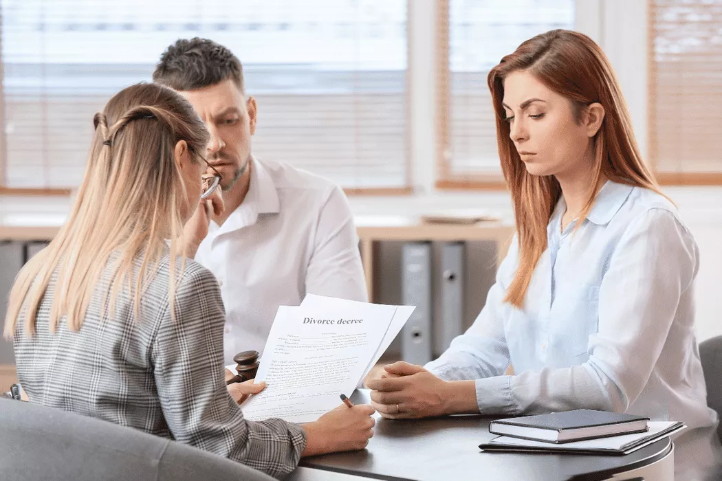A family lawyer in Toronto reviewing a divorce decree with a couple during a consultation, symbolizing Nussbaum family lawyers working on family legal matters.