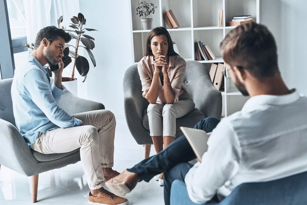 A couple sitting apart in a modern office, appearing tense during a consultation with a family lawyer, representing the theme of Nussbaum family lawyers in Toronto handling family legal matters.