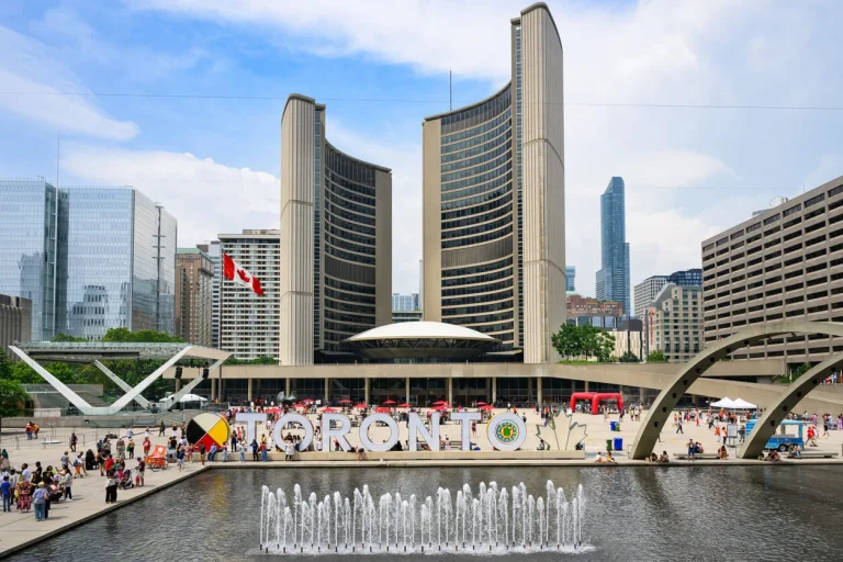 Toronto City Hall with the iconic TORONTO sign and a water fountain in the foreground, representing the vibrant city where Nussbaum Family Lawyers provide legal services specializing in family law issues.