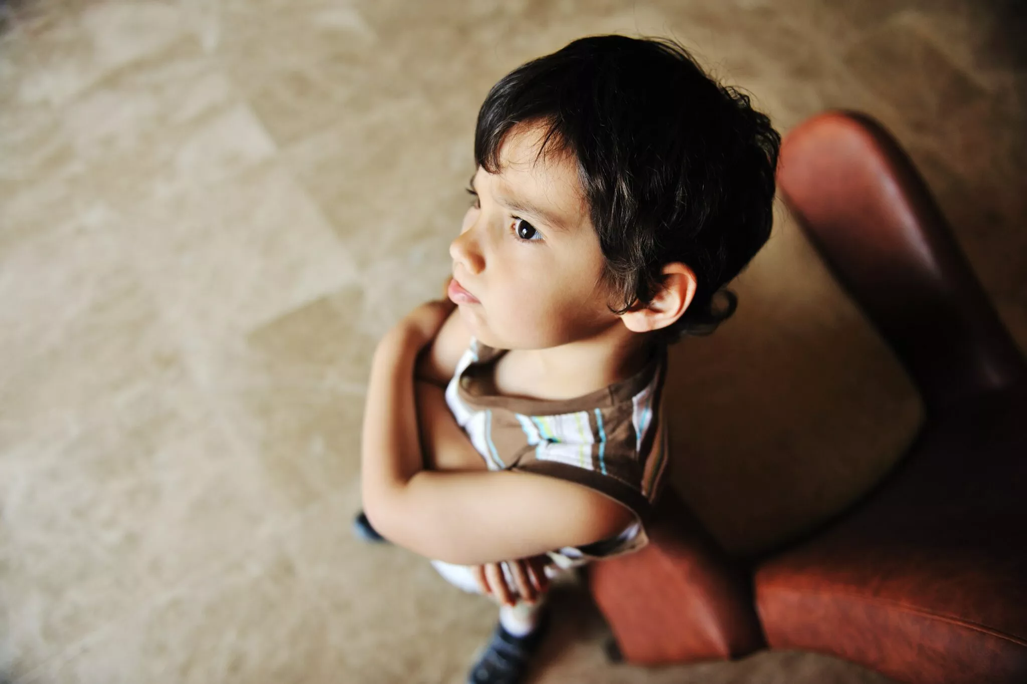 Young boy with folded arms looking worried, symbolizing a child in need of family law support in Toronto from Nussbaum Family Lawyers.