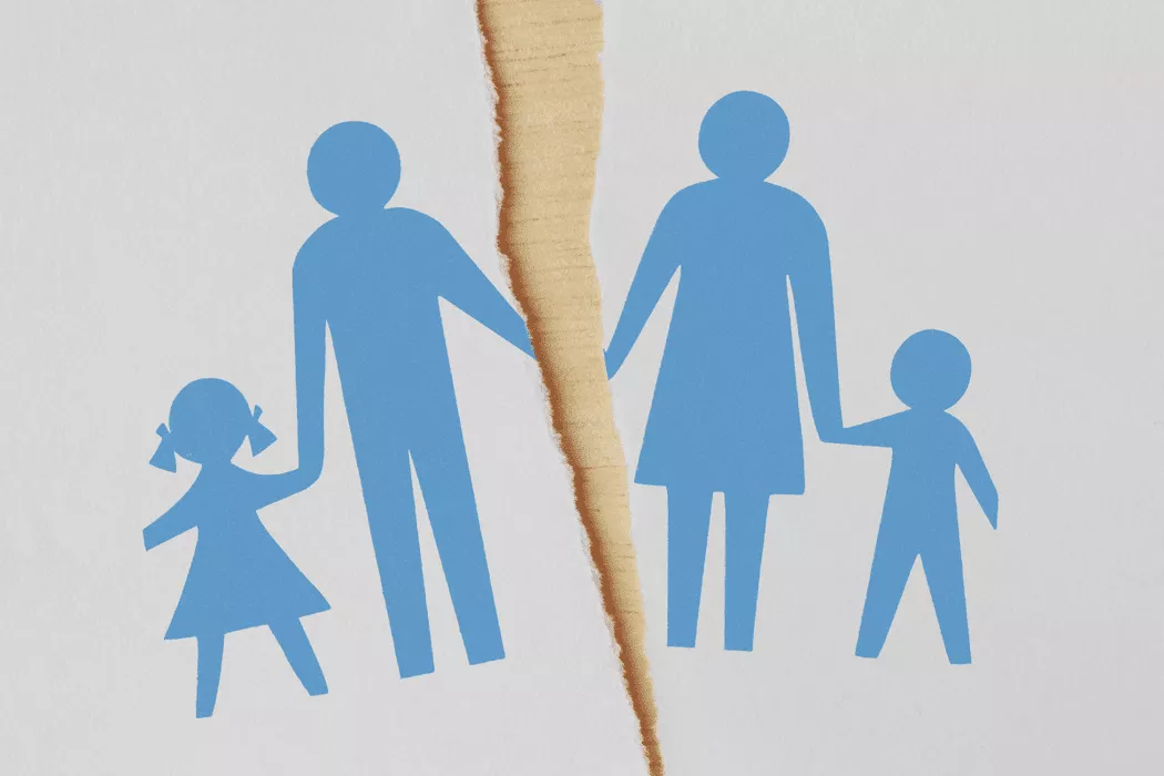 Blue paper cutout silhouettes of a family with two children, torn apart down the middle, symbolizing family separation or divorce, representing the theme of family law services by Nussbaum family lawyers in Toronto.