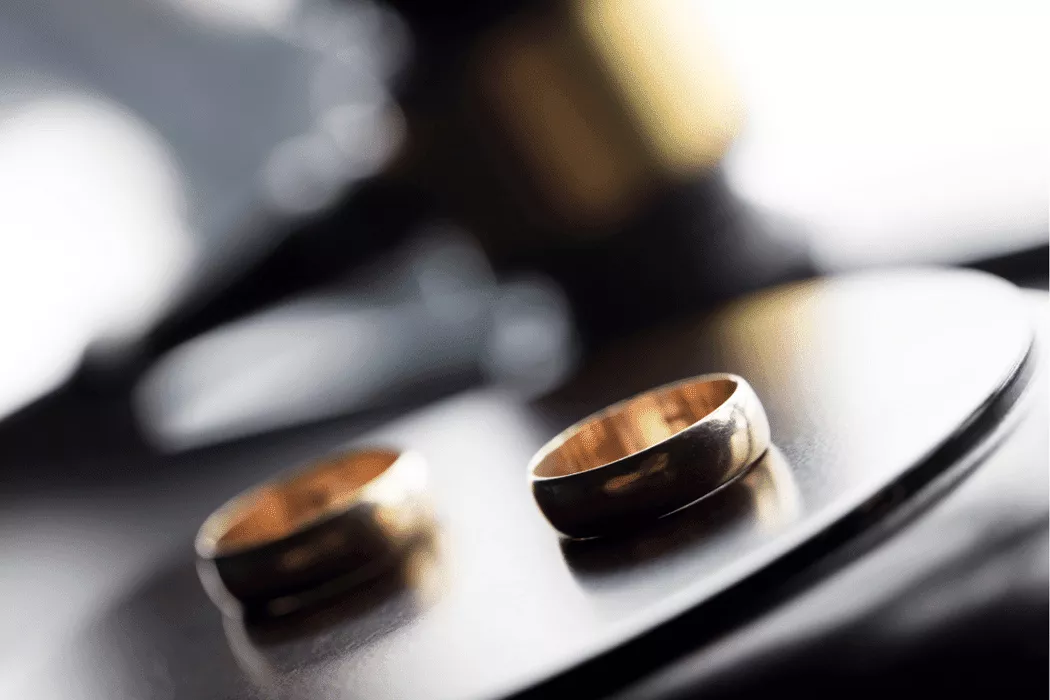 Two gold wedding rings placed on a reflective surface with a blurred background, symbolizing family law and divorce proceedings relevant to Nussbaum family lawyers in Toronto.